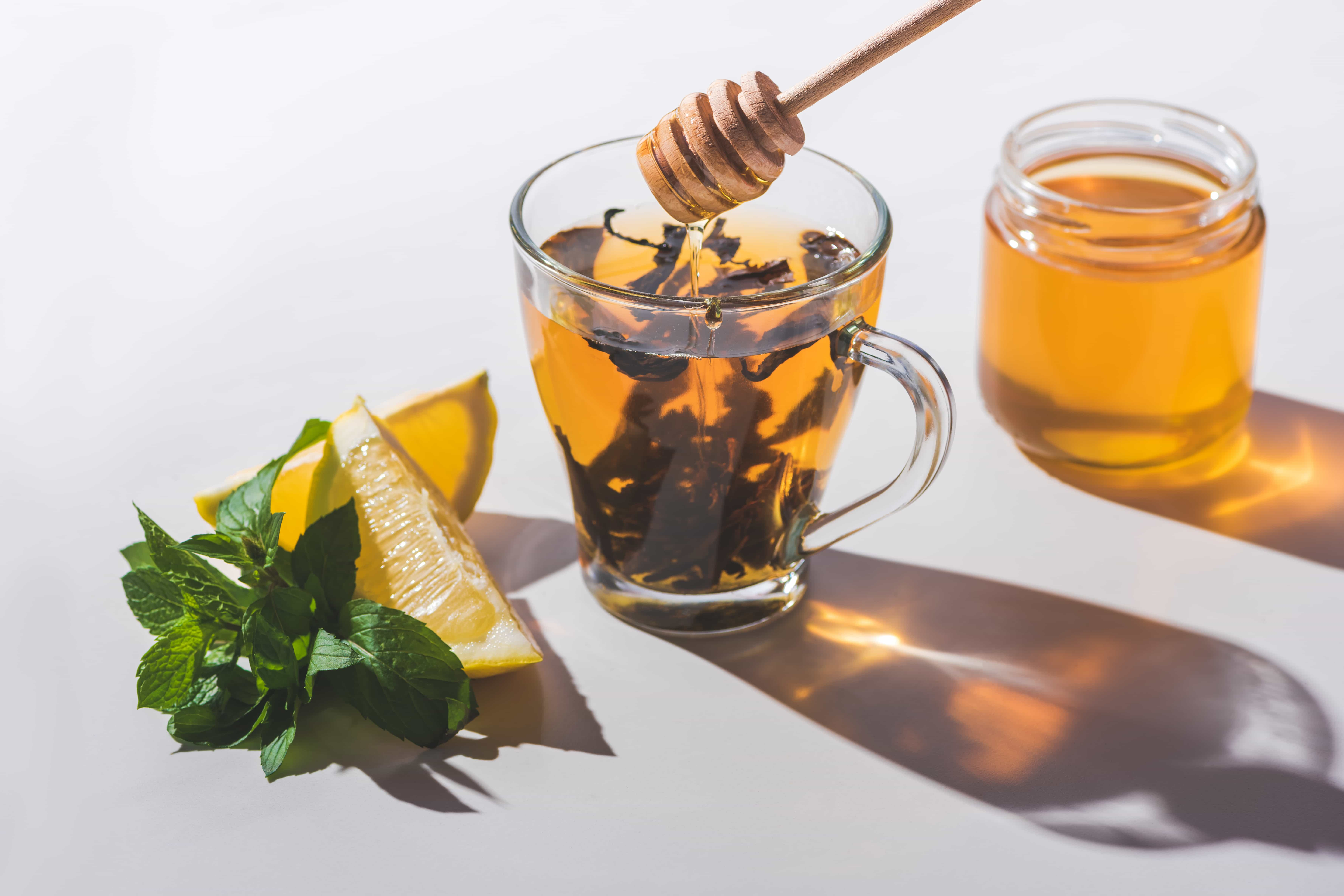 a honey comb dripping honey into a cup of tea