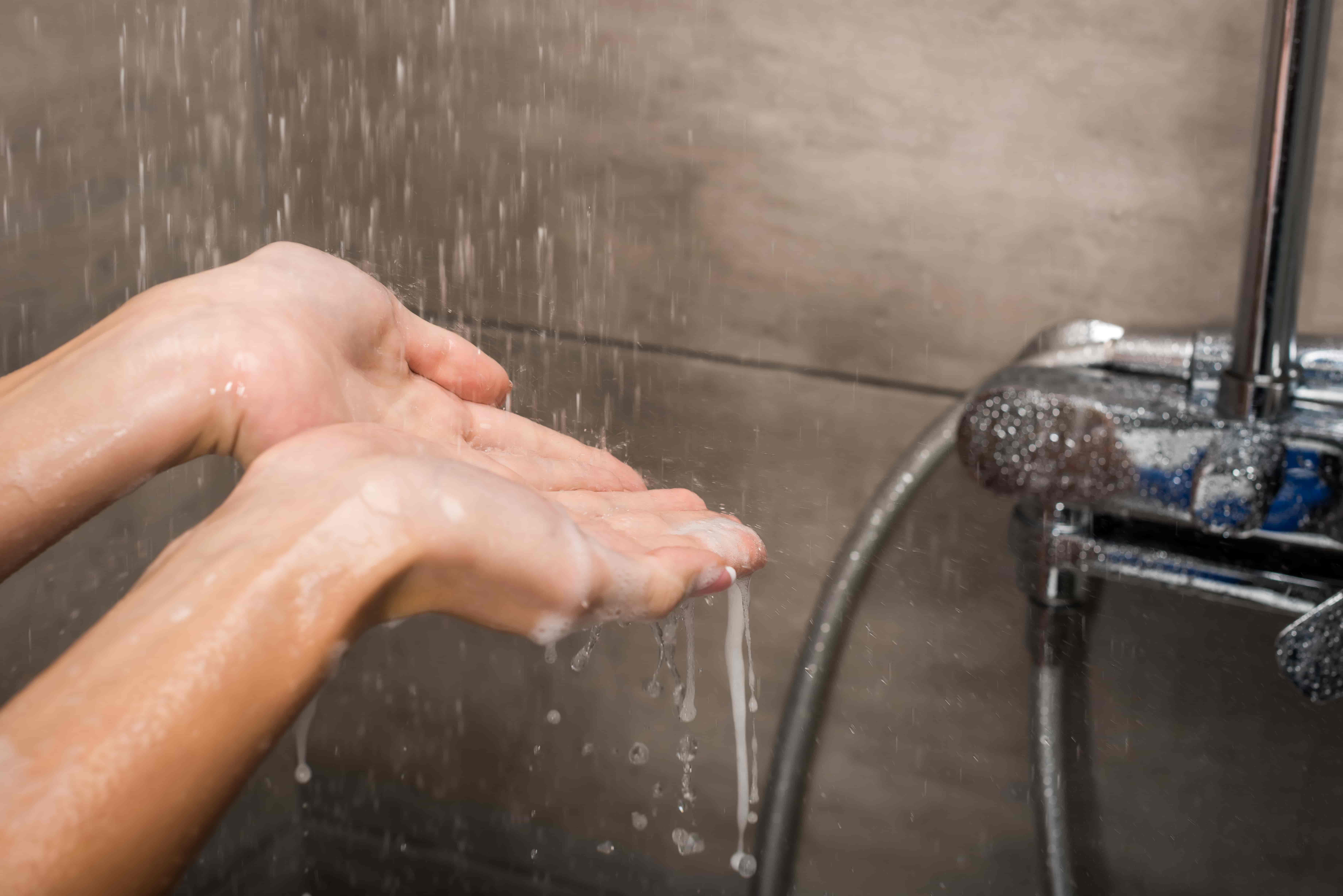 hands getting wet underneath a shower