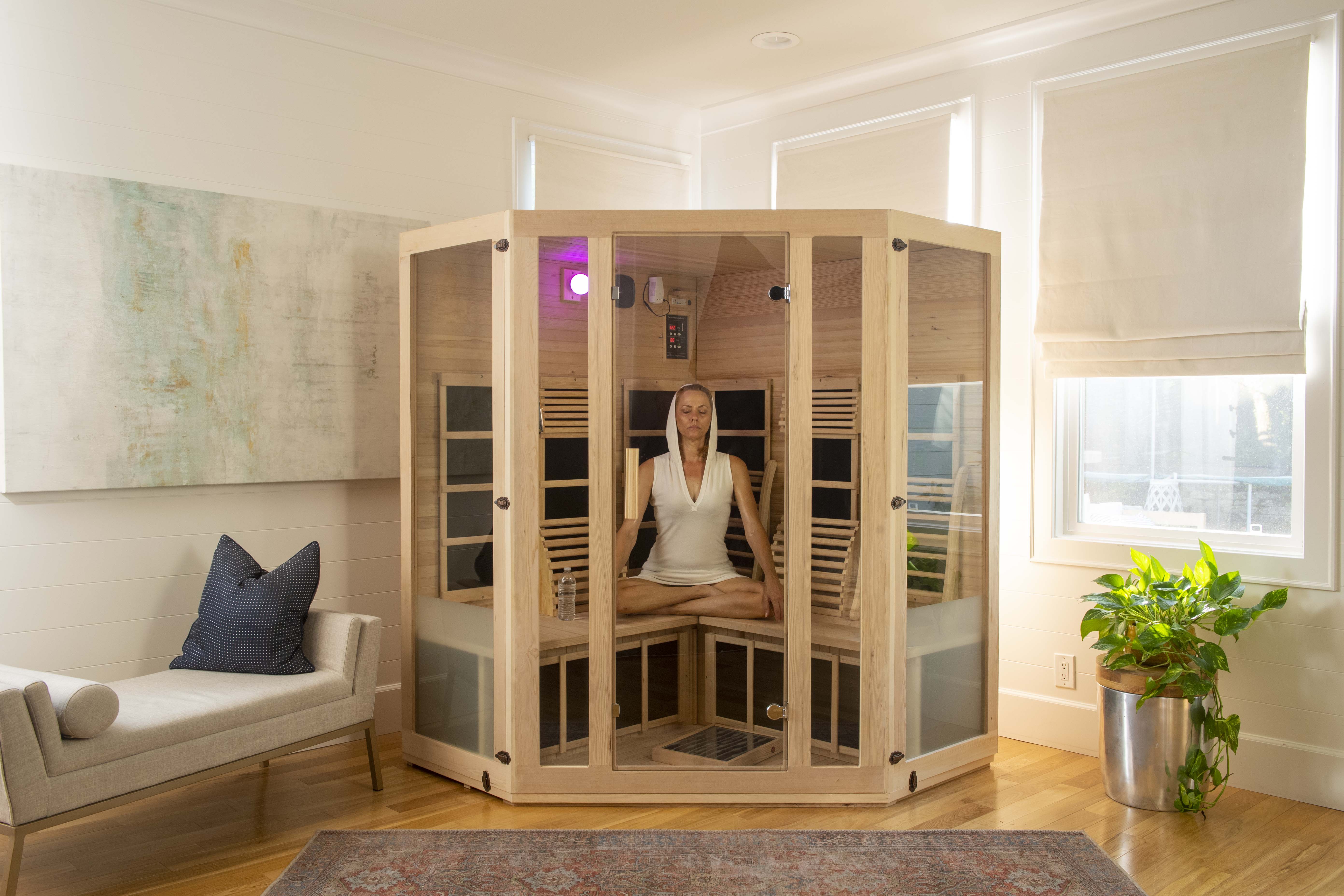 woman meditating inside of a far infrared sauna by JNH Lifestyles