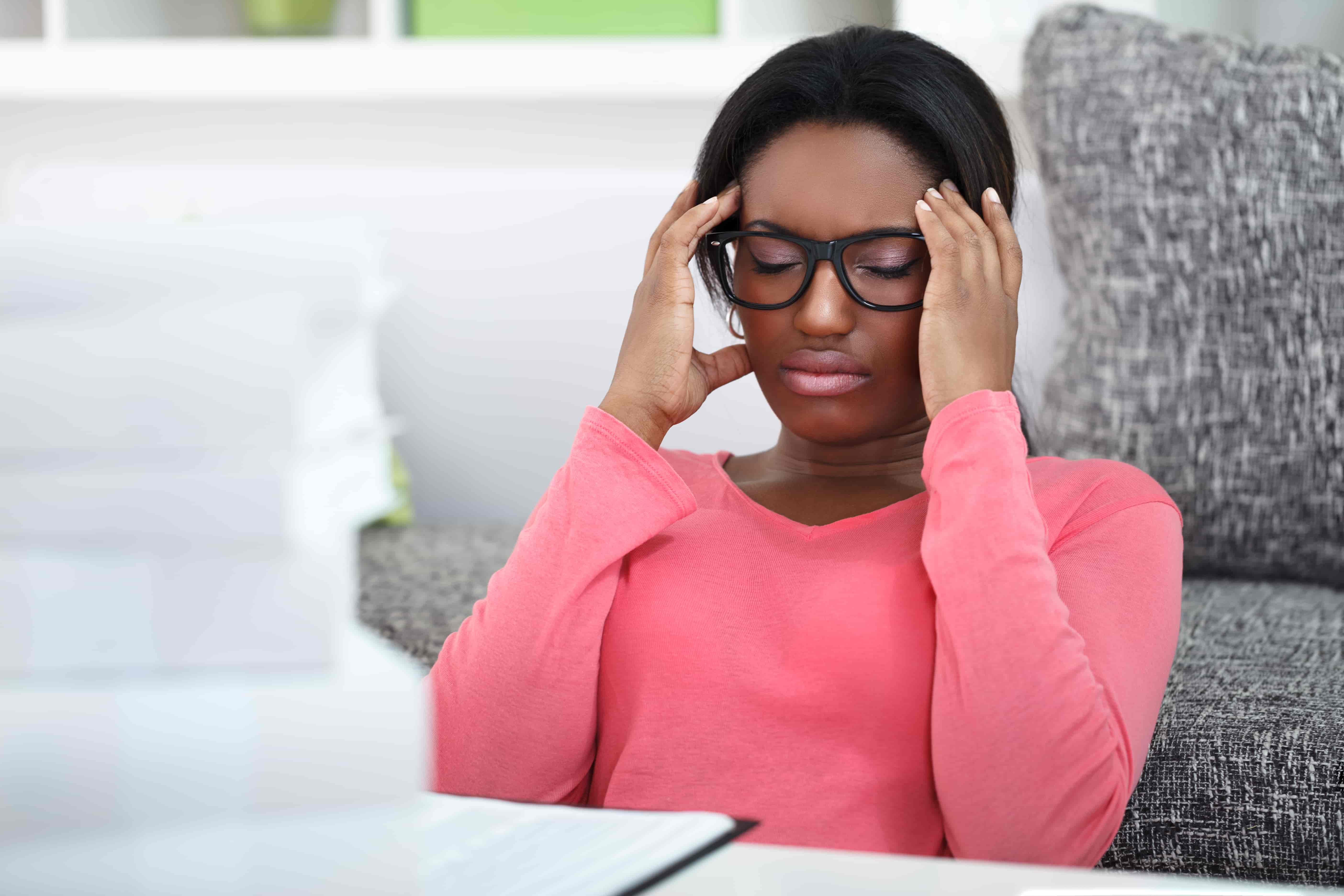 woman holding her temples while in stress